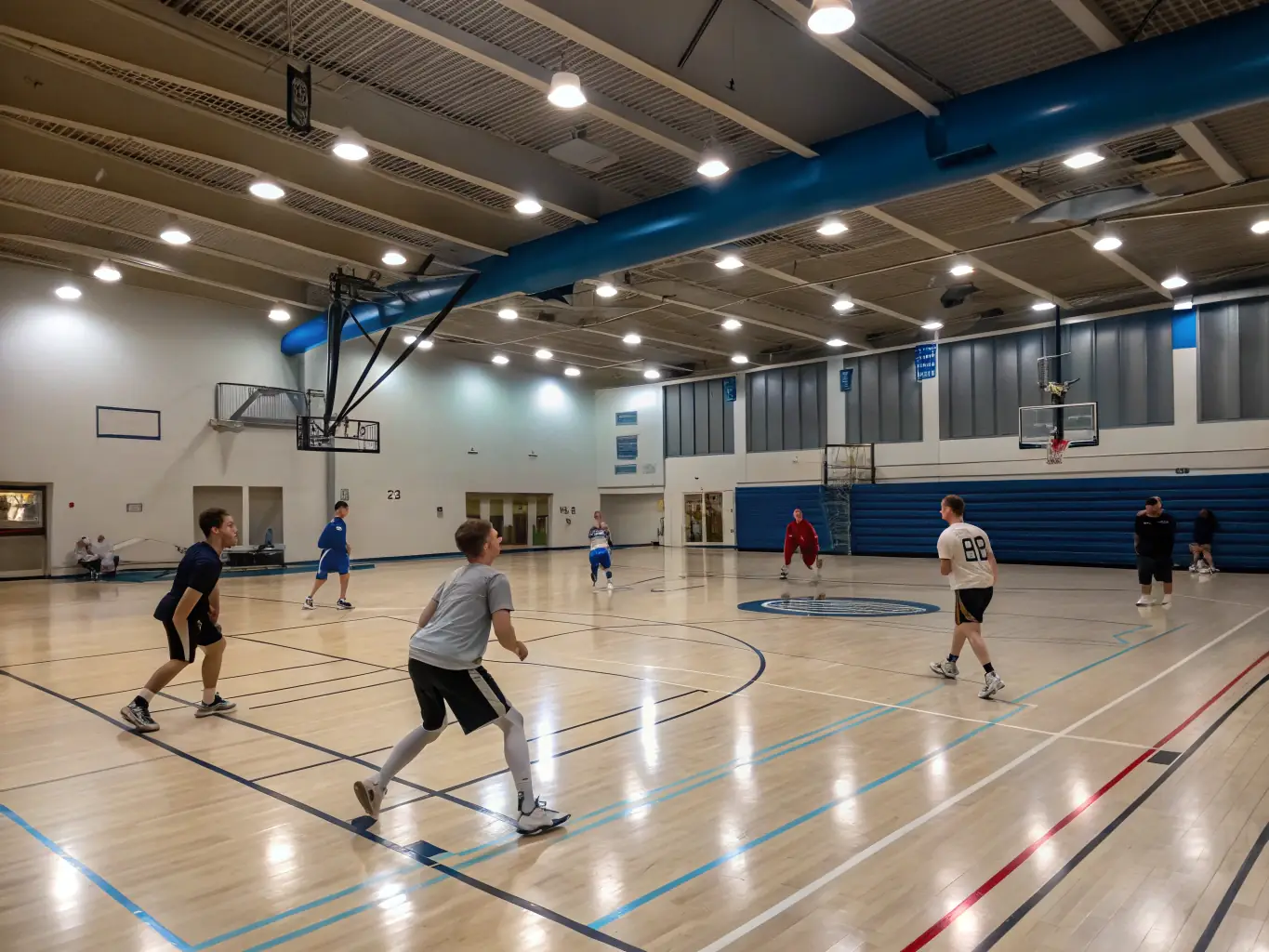 A brightly lit indoor basketball court with members of all ages and skill levels participating in a friendly game, showcasing the center's inclusive atmosphere.